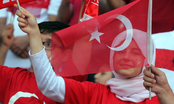 Tifozë turq festojnë me flamujt kombëtarë gjatë ndeshjes së skuadrës së tyre përballë Hollandës për grupin A të Euro 2016, ndeshje të cilën skuadra turke e fitoi me rezultatin e thellë 3 me 0. (AP Photo)