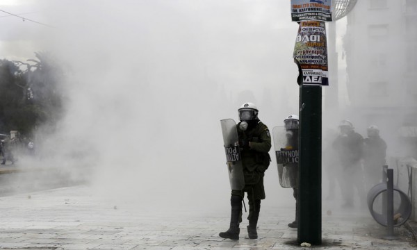 Policët grekë po qëndrojnë mes tymit gjatë përleshjeve me protestuesit më 4 shkurt 2016 në Athinë. (AP Photo/Petros Giannakouris)