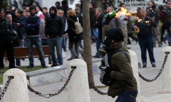 Një protestues i maskuar hedh një bombë molotov kundër policisë më 4 shkurt 2016 në qendër të Athinës. (AP Photo/Petros Giannakouris) 