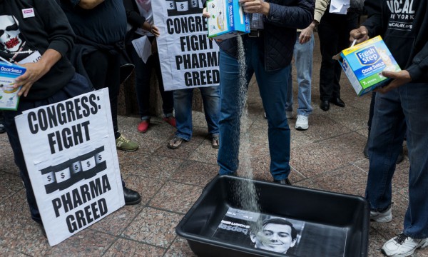 Aktivistët për të drejtat e njerëzve me AIDS derdhin jashtëqitje maceje mbi foton e Martin Shkrelit në një protestë të zhvilluar më 1 tetor 2015 kundër babëzisë së kompanive farmaceutike. (AP)